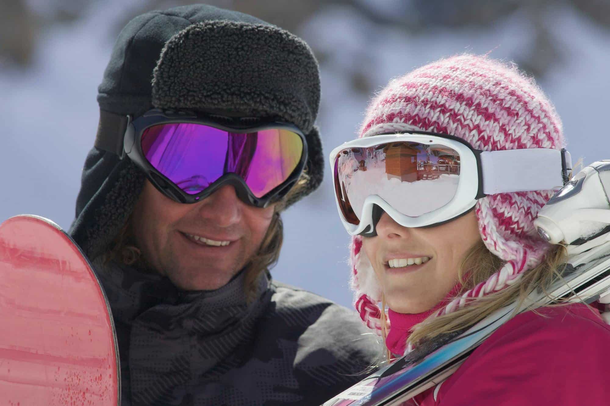 Smiling couple wearing ski goggles
